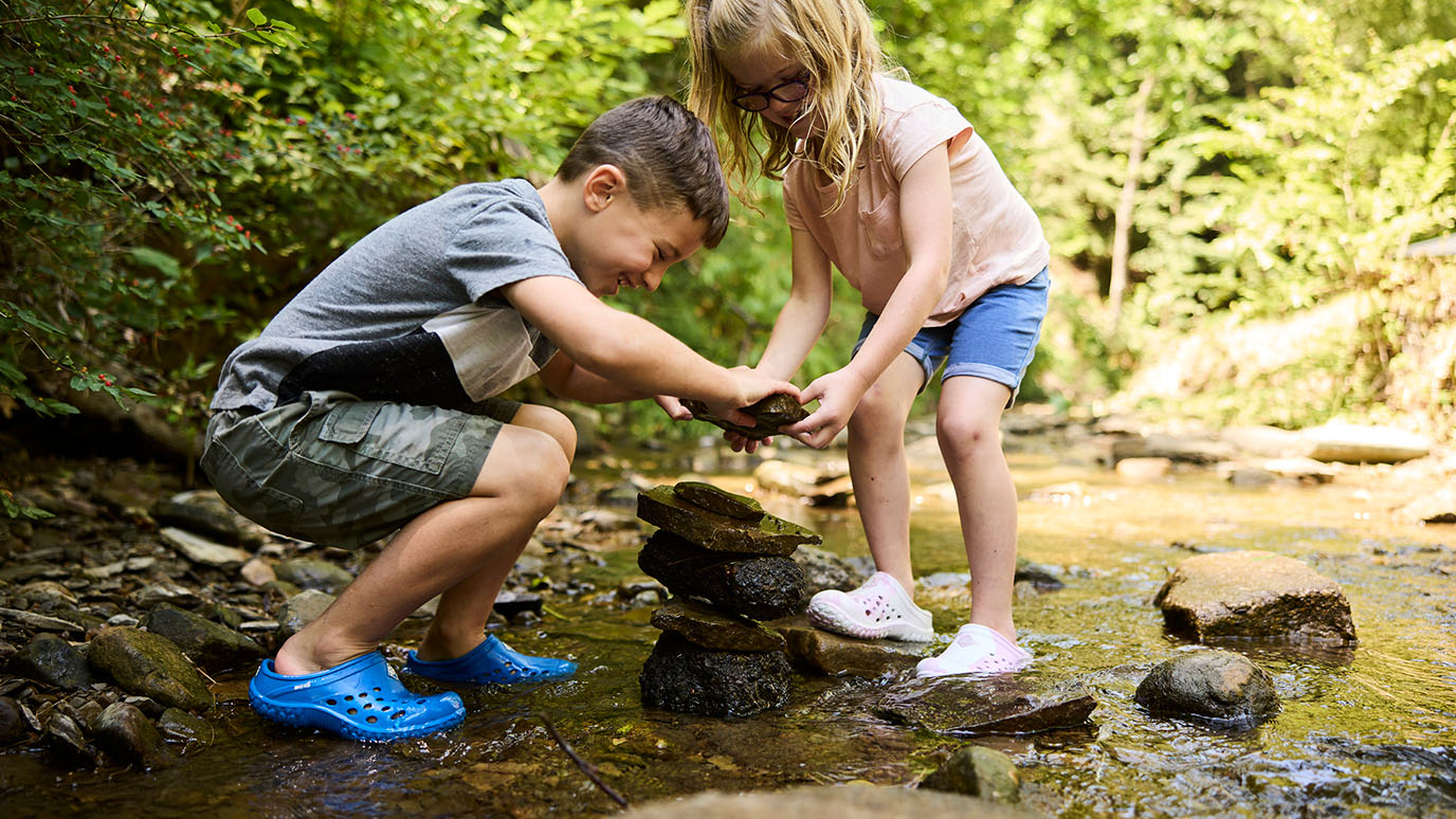 Two kids playing in stream in their Muckster Lite Clog