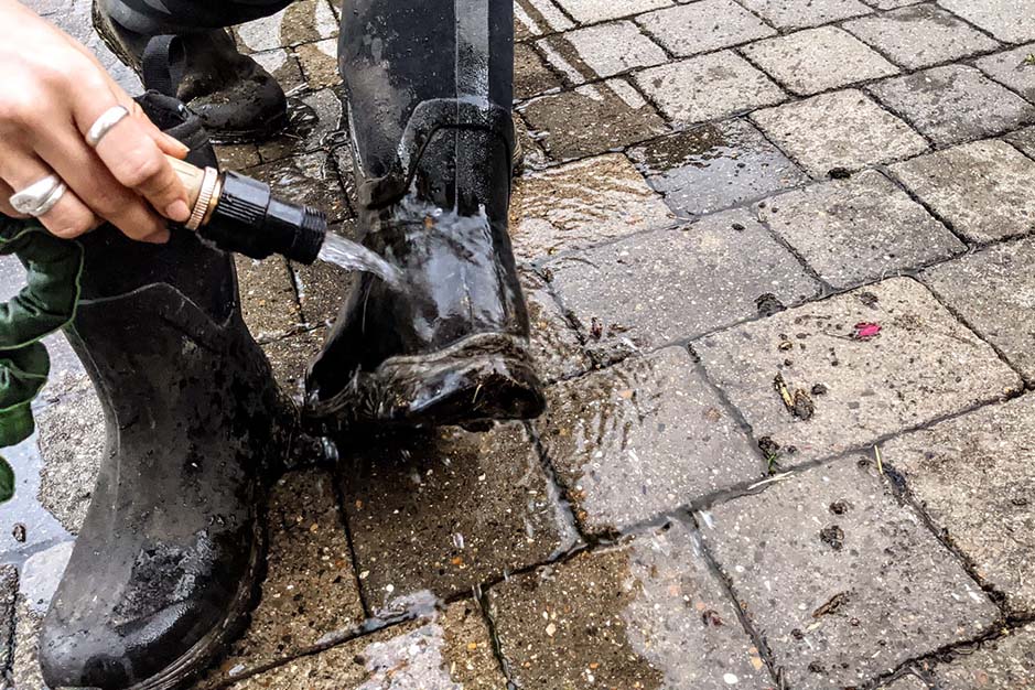 Rinsing Muck Boots off with a garden hose