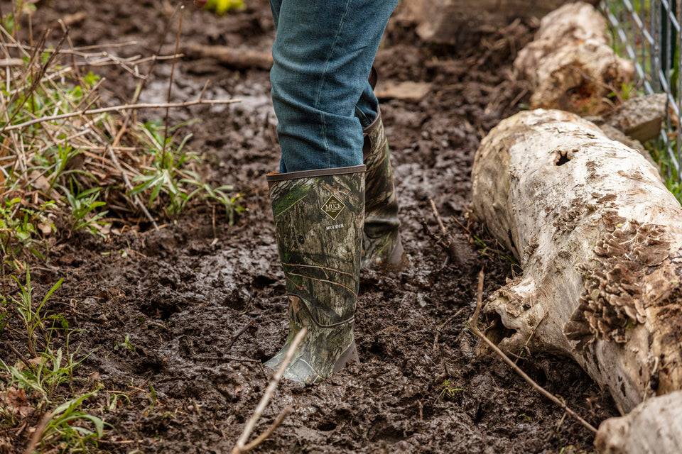 Person walking in deep mud wearing Muck Mudder Boots