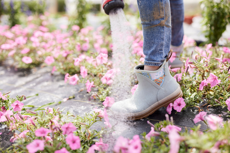 Women spraying off her Muck Originals Boots