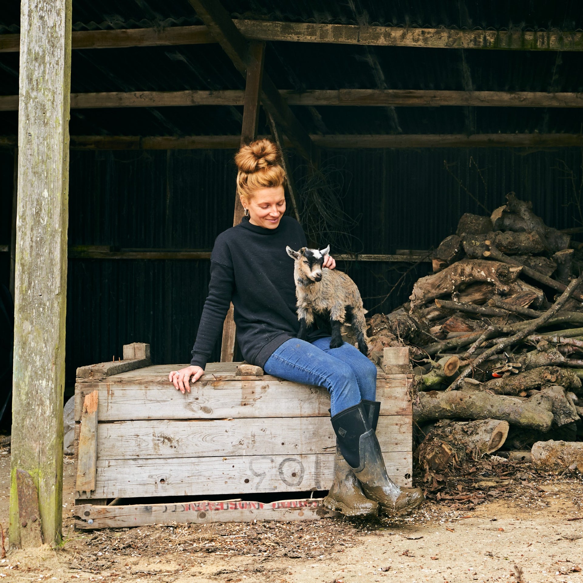 Zoe C. sitting with a baby goat in her lap