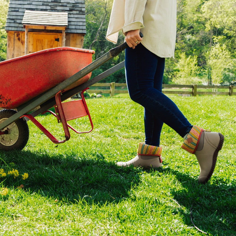 Women moving wheel barrel wearing Muck Garden Boots