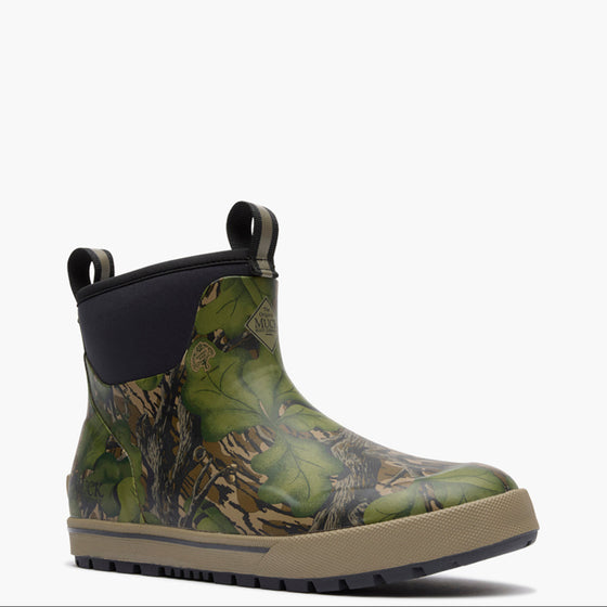 Green camouflage Muck boot with a black sole on a white background