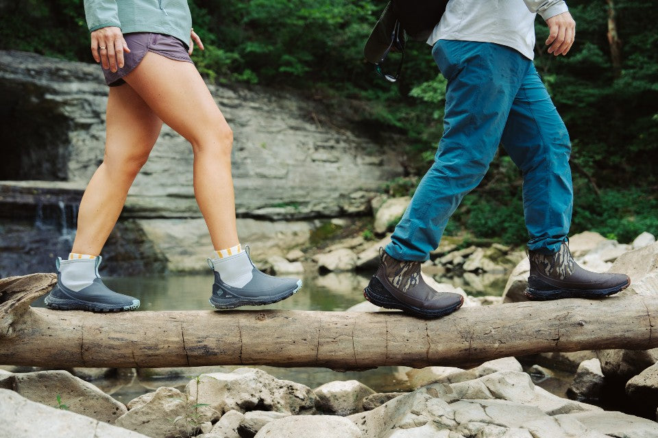 Man and woman crossing a creek bed