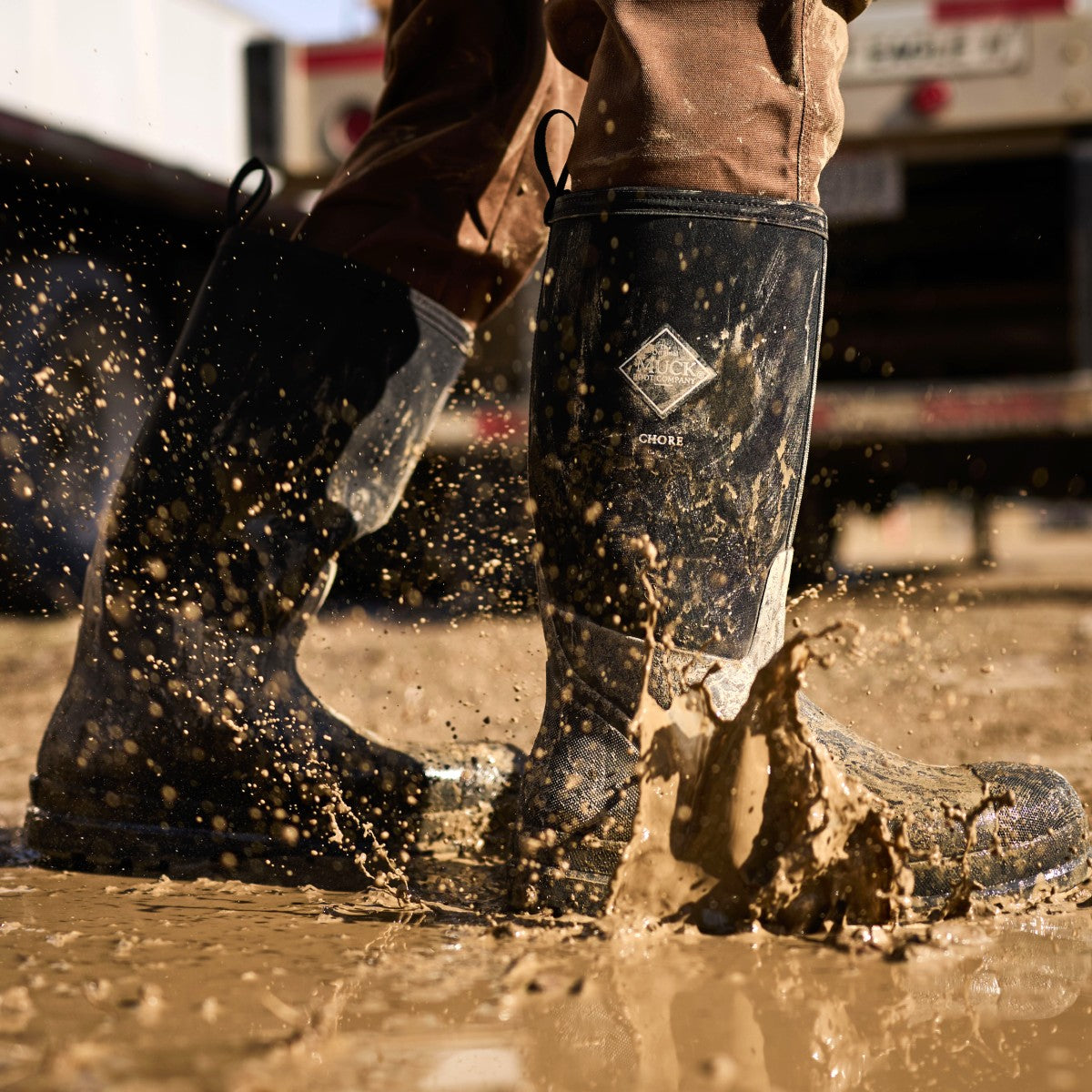 Person wearing Muck Chore Boots walking through mud.
