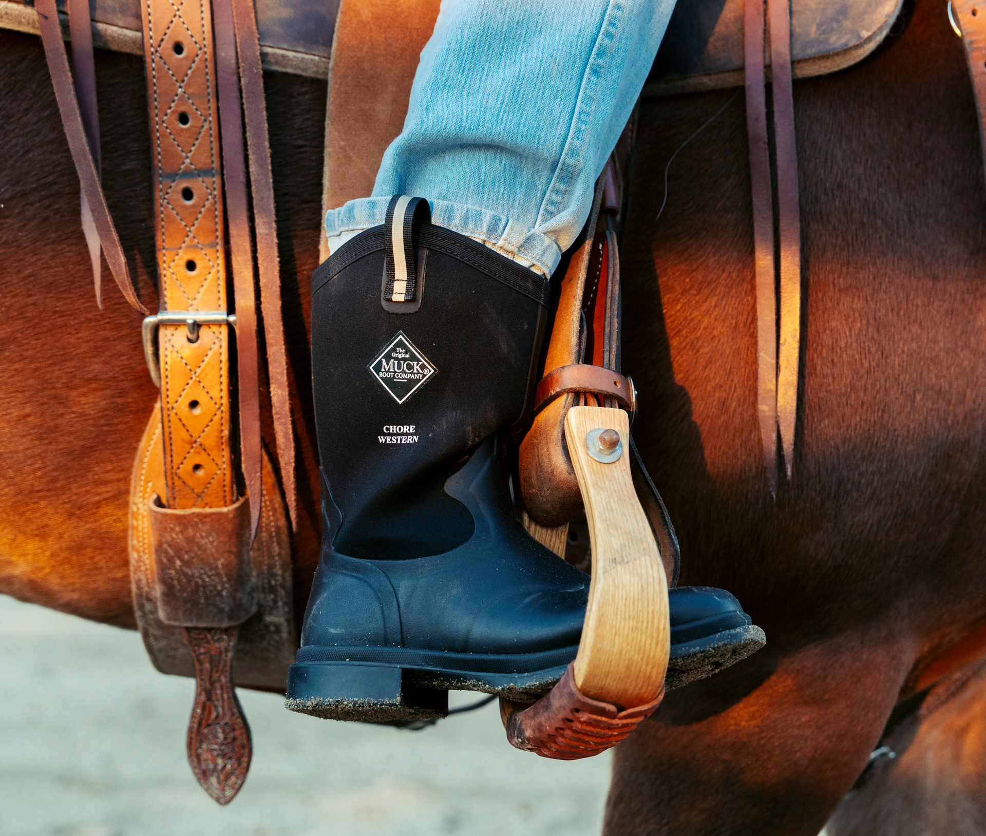 Black boot with a visible brand logo on a horse saddle