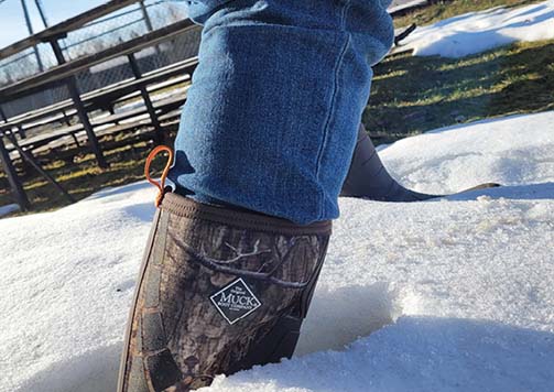 Man walking in snow wearing Muck Boots