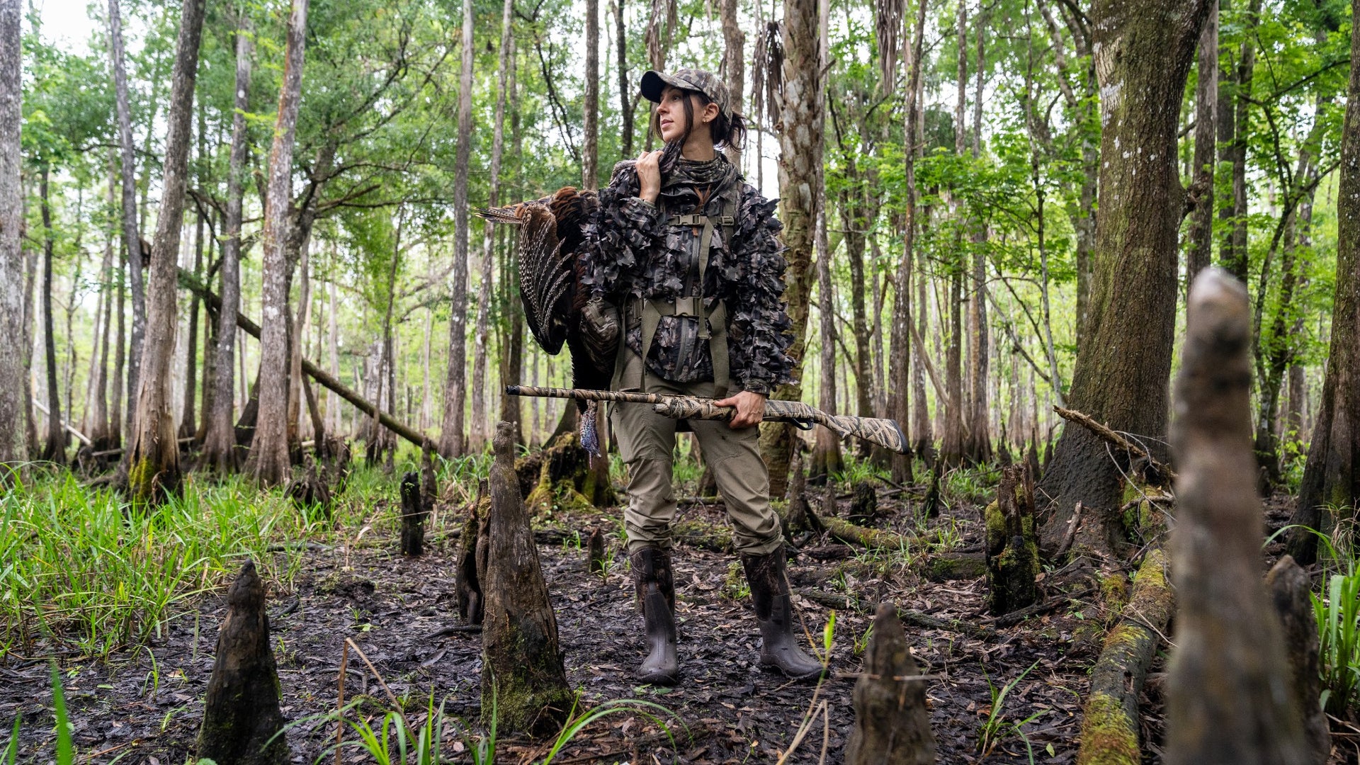 Allie D. holding her shotgun and turkey kill.