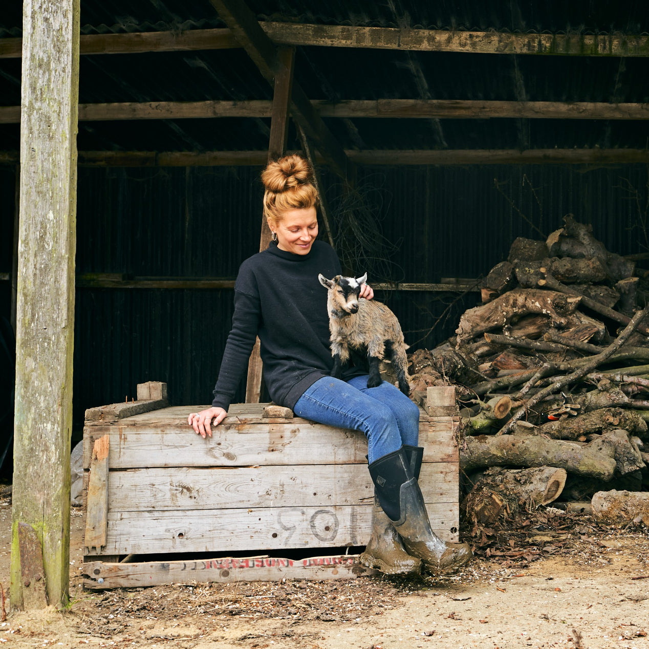 Zoe C. sitting with a baby goat in her lap