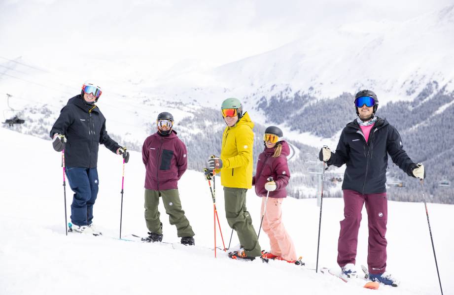 Professional Ski Instructors of America - American Association of Snowboard Instructors (PSIA-AASI). Five skiers in colorful outfits on a snowy mountain