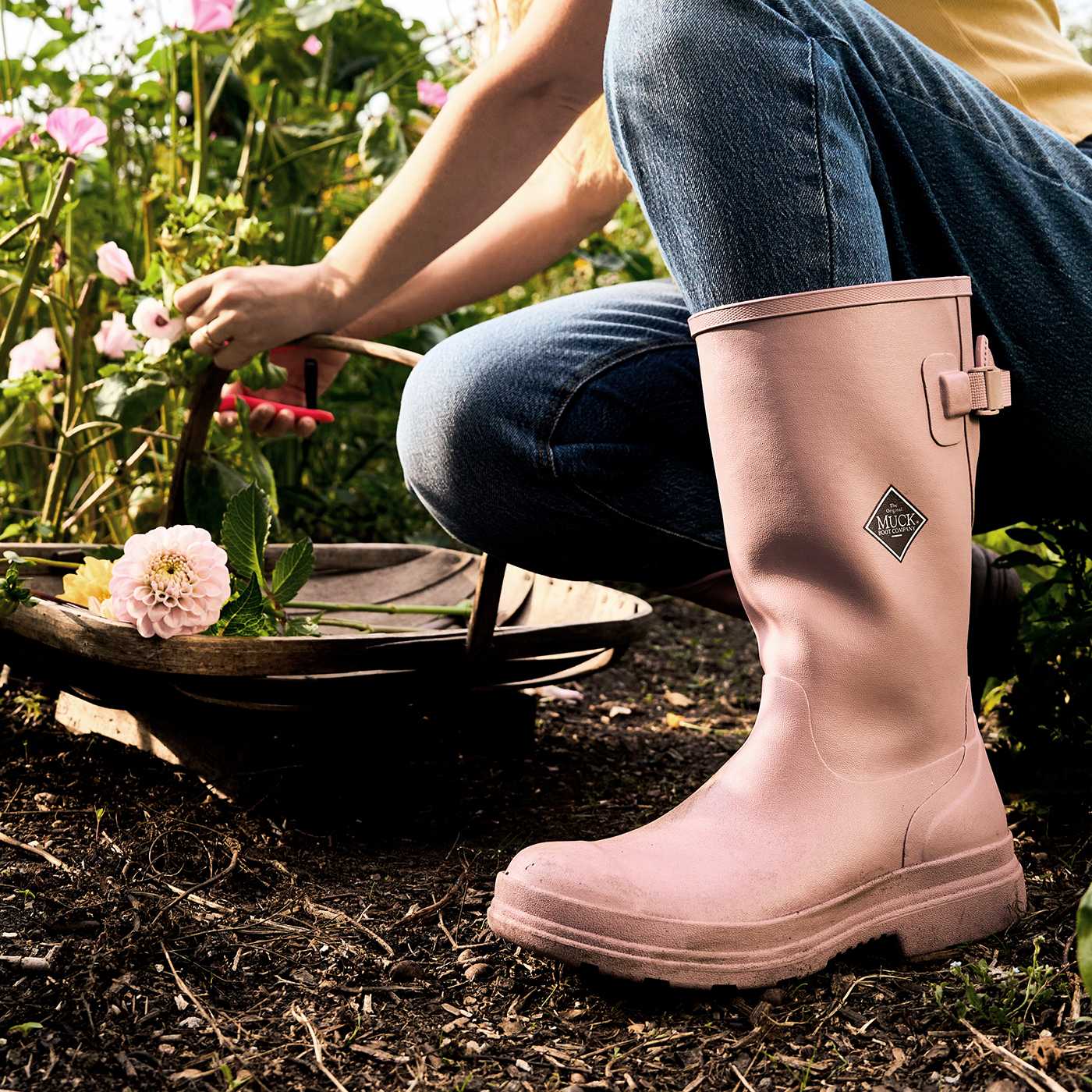Person wearing pink rubber boots in a garden setting