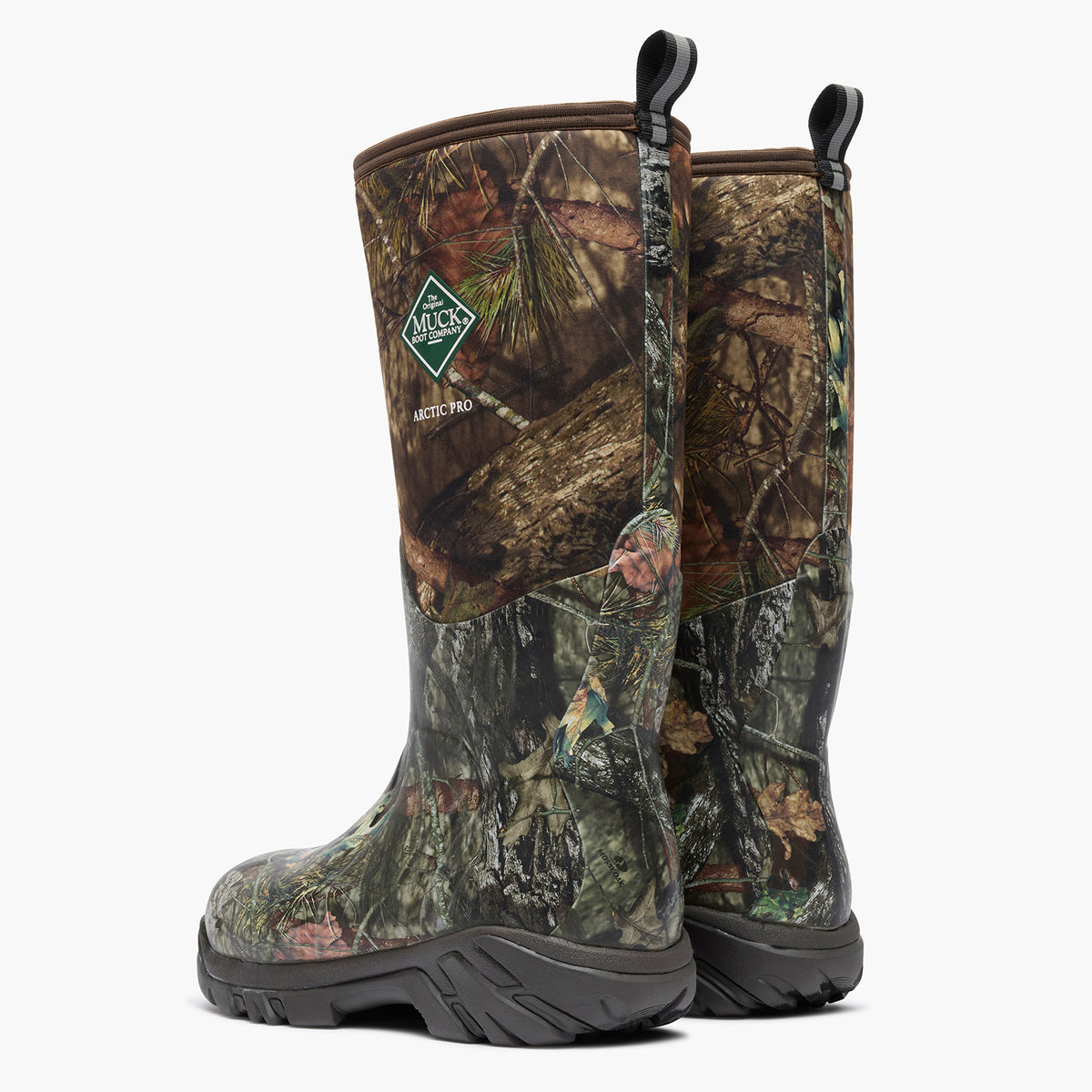 A pair of Mossy Oak insulated hunting boots in a realistic woodland camouflage pattern, featuring a green Mossy Oak logo patch on the side, black pull tabs, and thick black soles, set against a plain white background.