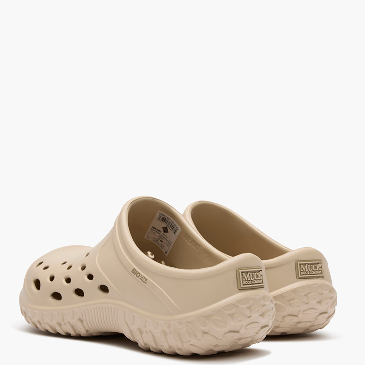 Pair of beige clogs on a white background